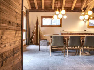 Experience the warmth of this inviting dining area, featuring a stunning wooden ceiling and elegant globe pendant lights.