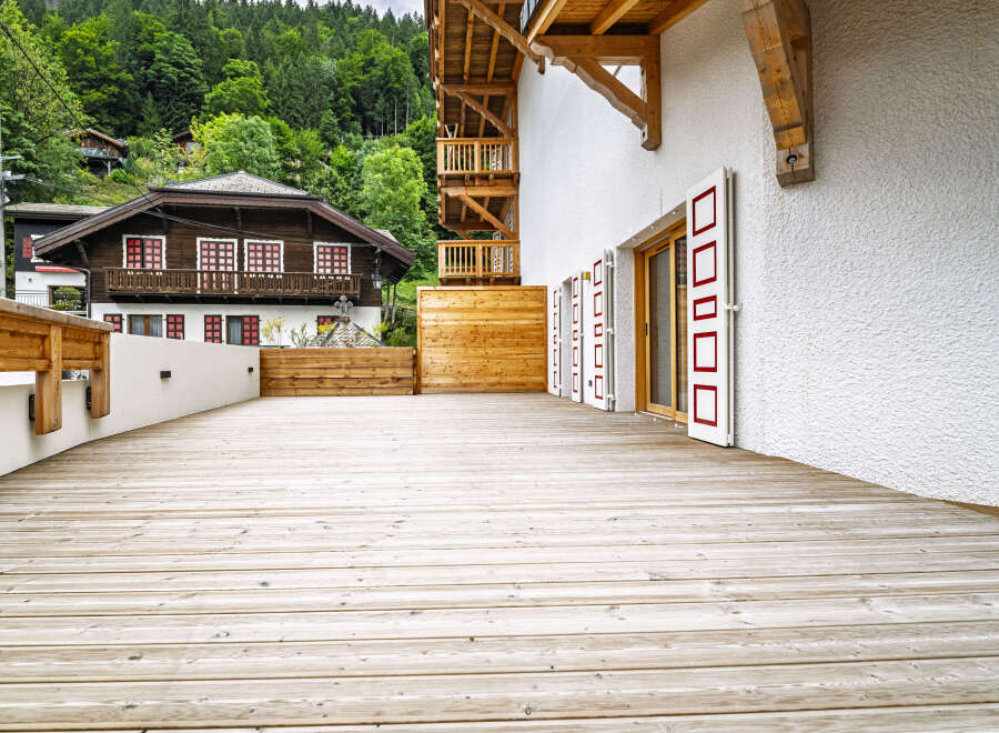 Experience the charm of alpine living with this stunning property featuring a spacious wooden deck perfect for outdoor entertaining.