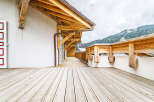 Experience the charm of this alpine property with its expansive wooden deck, perfect for enjoying the breathtaking mountain views.