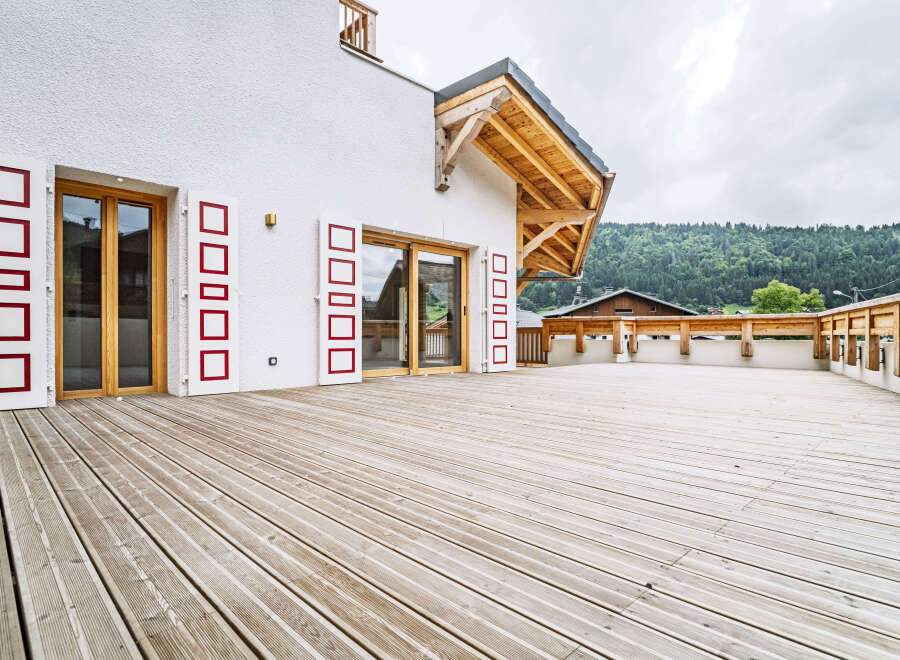 Experience modern alpine living with this stunning property featuring a spacious wooden deck perfect for outdoor entertaining.