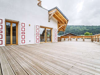 Experience modern alpine living with this stunning property featuring a spacious wooden deck perfect for outdoor entertaining.
