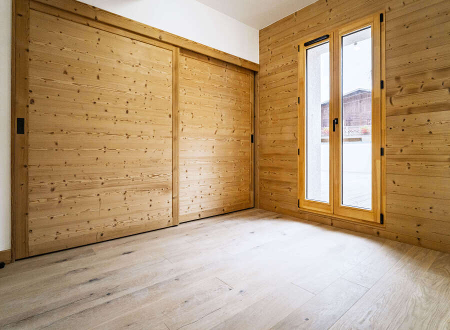 Experience rustic charm and modern comfort in this beautifully appointed room featuring warm, natural wood paneling on the walls and ceiling.