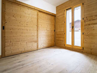Experience rustic charm and modern comfort in this beautifully appointed room featuring warm, natural wood paneling on the walls and ceiling.