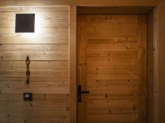 Experience rustic charm with this beautifully crafted wooden door, featuring a modern black handle and a subtle room number 'A104'.