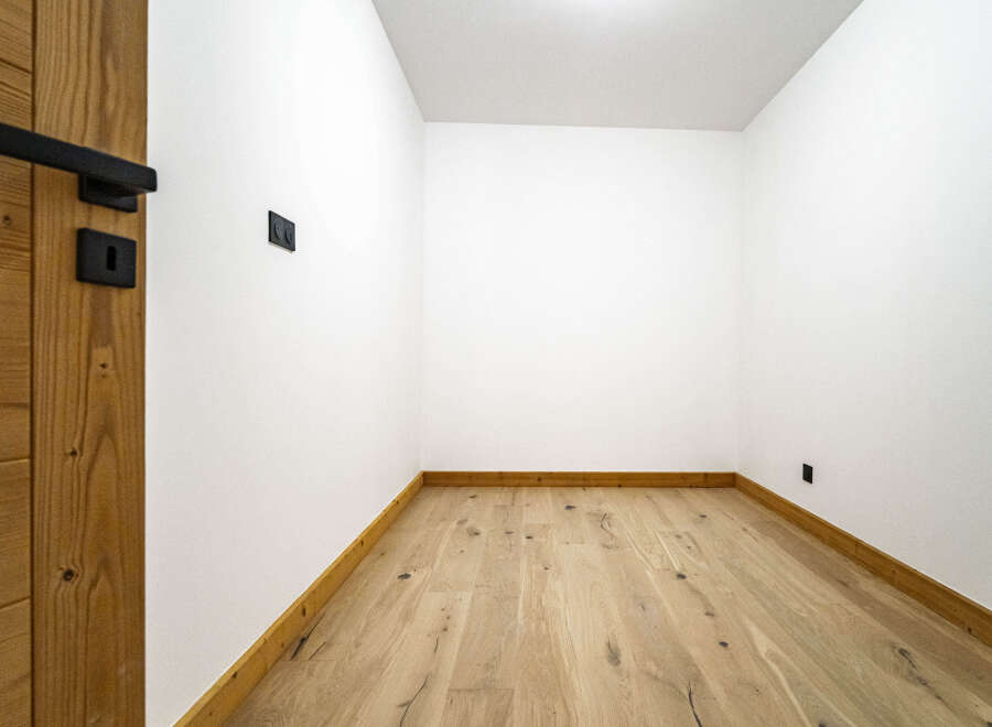 Experience modern living in this newly constructed space featuring sleek black fixtures and a warm, natural wood floor.