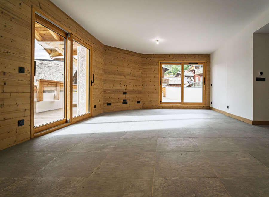 Experience modern alpine living in this stunning property featuring warm wood paneling and expansive sliding glass doors that open to breathtaking mountain views.