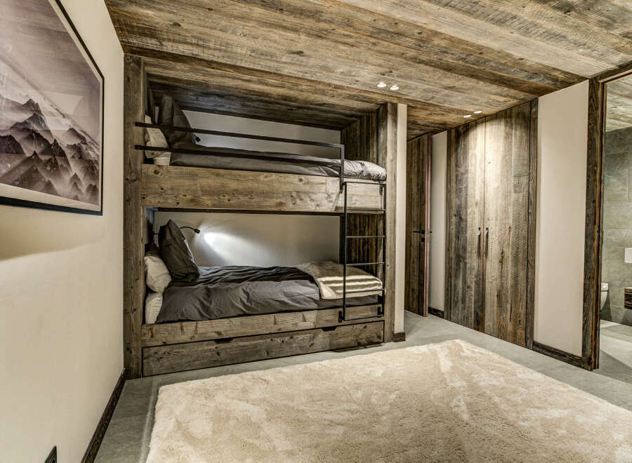 This cozy bedroom features a rustic bunk bed with a wooden frame, perfect for a mountain getaway.