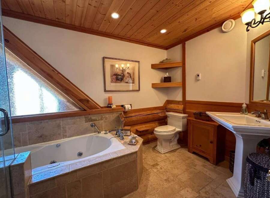 This luxurious bathroom features a stunning wooden ceiling and a relaxing jacuzzi tub.