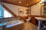 This luxurious bathroom features a stunning wooden ceiling and a relaxing jacuzzi tub.