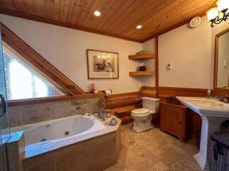 This luxurious bathroom features a stunning wooden ceiling and a relaxing jacuzzi tub.