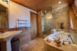 Step into luxury with this stunning bathroom! Featuring a spa-like jacuzzi tub, a separate glass-enclosed shower, and elegant wooden accents throughout.