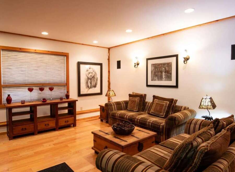 This cozy living room features a warm and inviting atmosphere with its wooden floors and comfortable seating.