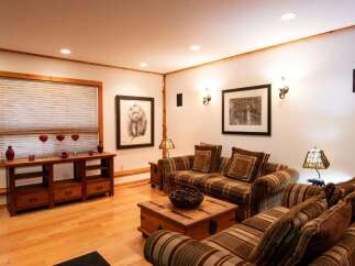 This cozy living room features a warm and inviting atmosphere with its wooden floors and comfortable seating.