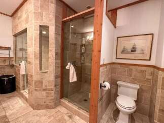 This luxurious bathroom features a stunning walk-in shower with glass doors and elegant tile work.