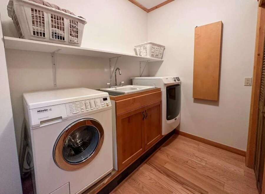 This laundry room features a Miele washing machine and a sink, offering convenience and functionality.