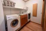 This laundry room features a Miele washing machine and a sink, offering convenience and functionality.