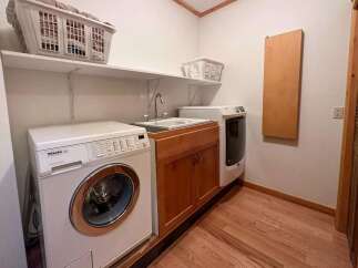 This laundry room features a Miele washing machine and a sink, offering convenience and functionality.