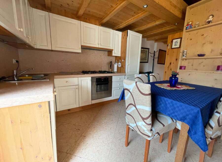 Cozy kitchen with wooden ceiling and cabinets.