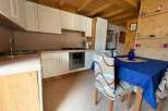Cozy kitchen with wooden ceiling and cabinets.