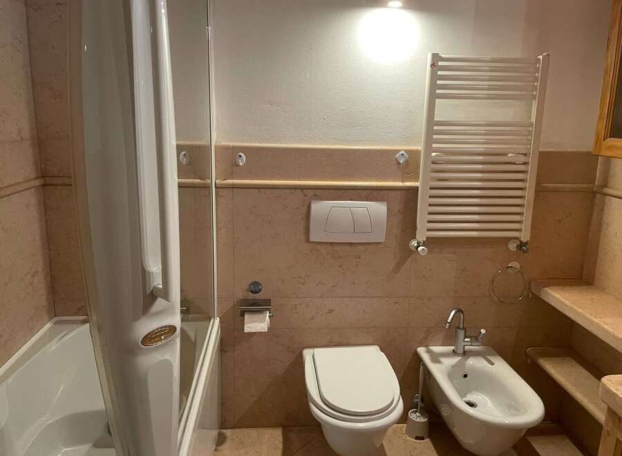 This bathroom features a modern design with a sleek shower enclosure and a comfortable toilet.