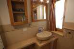 This charming bathroom features a unique stone sink and a wooden vanity, creating a warm and inviting atmosphere.