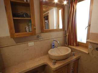 This charming bathroom features a unique stone sink and a wooden vanity, creating a warm and inviting atmosphere.