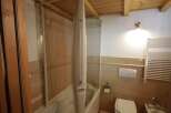 This bathroom boasts a bathtub with a sleek, folding shower screen, making it perfect for relaxation and functionality.