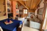 Charming living area featuring a wooden ceiling with exposed beams, adding warmth and character.