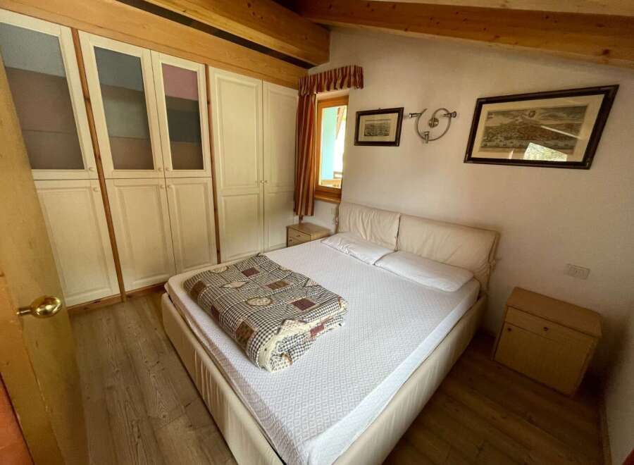 This inviting bedroom features a comfortable bed with a crisp white comforter and a patterned throw blanket, perfect for a relaxing stay.