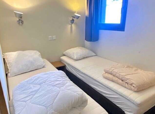 Cozy and inviting bedroom featuring two comfortable single beds, perfect for a relaxing stay.