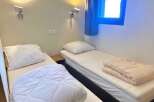 Cozy and inviting bedroom featuring two comfortable single beds, perfect for a relaxing stay.