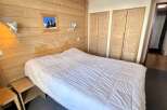 Cozy bedroom with wooden paneling and a comfortable bed.
