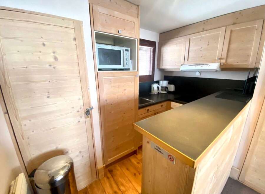 Discover a cozy kitchen with wooden cabinets and a sleek countertop.