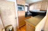 Discover a cozy kitchen with wooden cabinets and a sleek countertop.