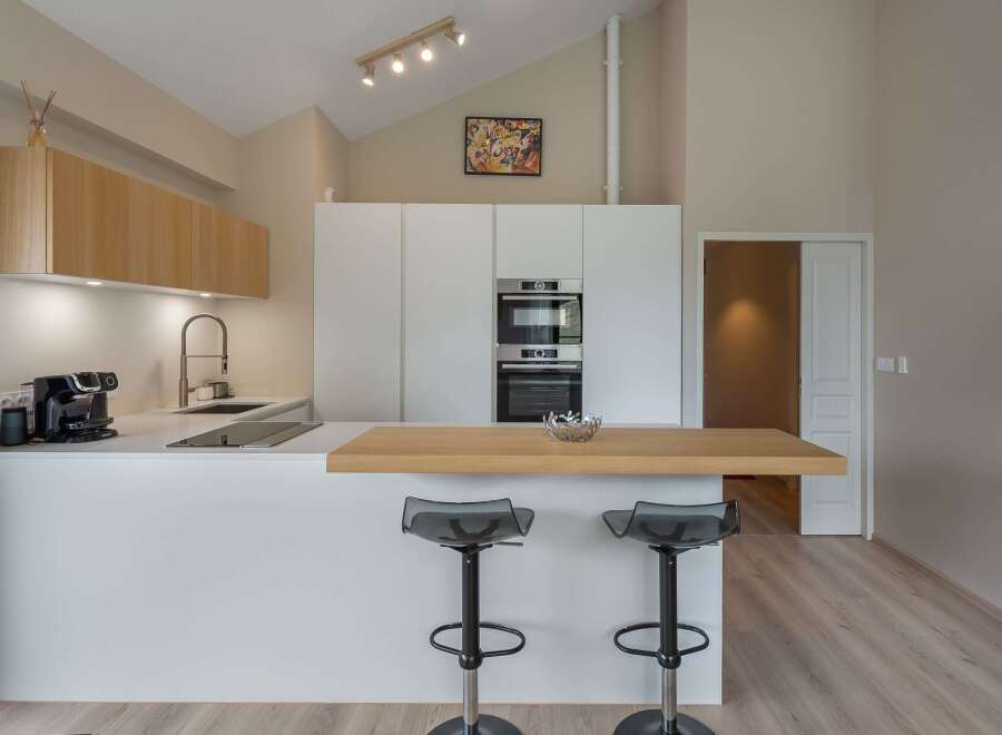 Modern kitchen design with sleek white cabinetry and a stylish breakfast bar.