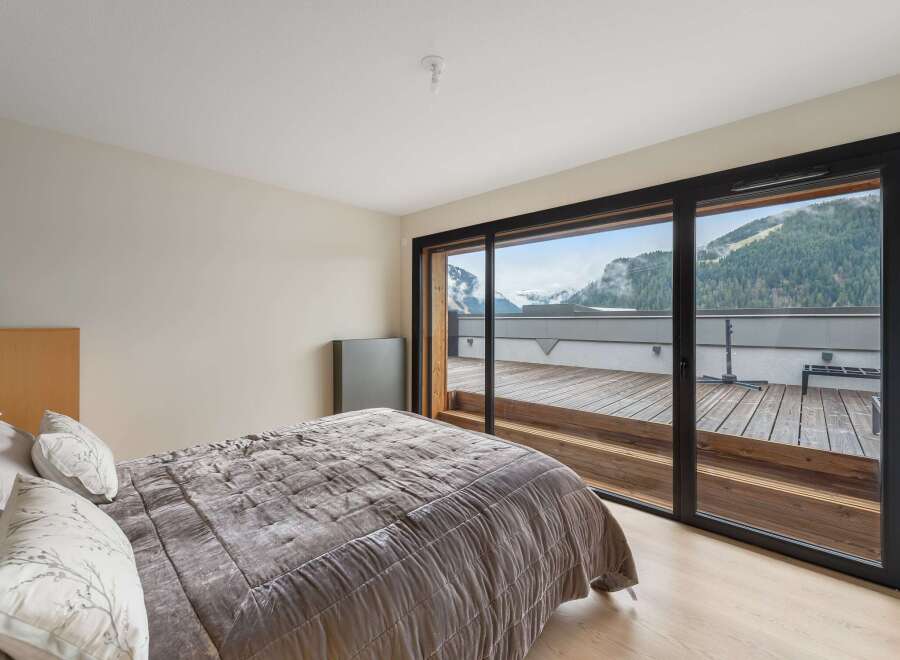 Experience breathtaking mountain views from this luxurious bedroom.