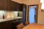Discover a modern kitchen with sleek dark wood cabinetry and a stainless steel backsplash.