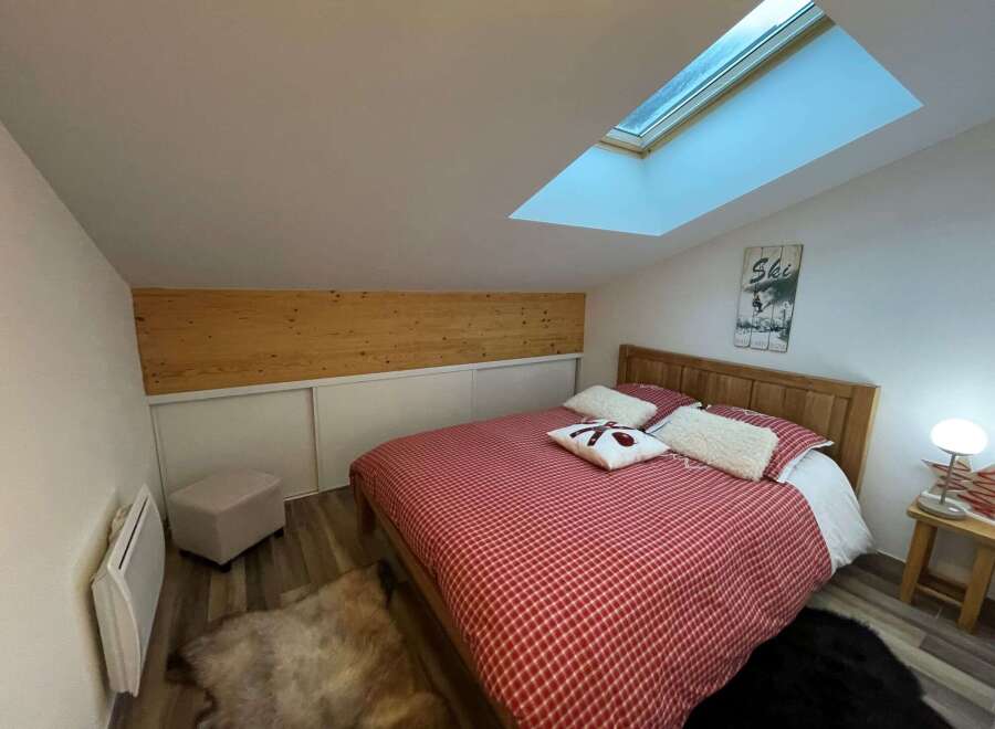 Cozy bedroom with a unique skylight, perfect for a relaxing getaway.