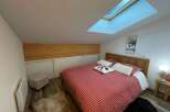 Cozy bedroom with a unique skylight, perfect for a relaxing getaway.