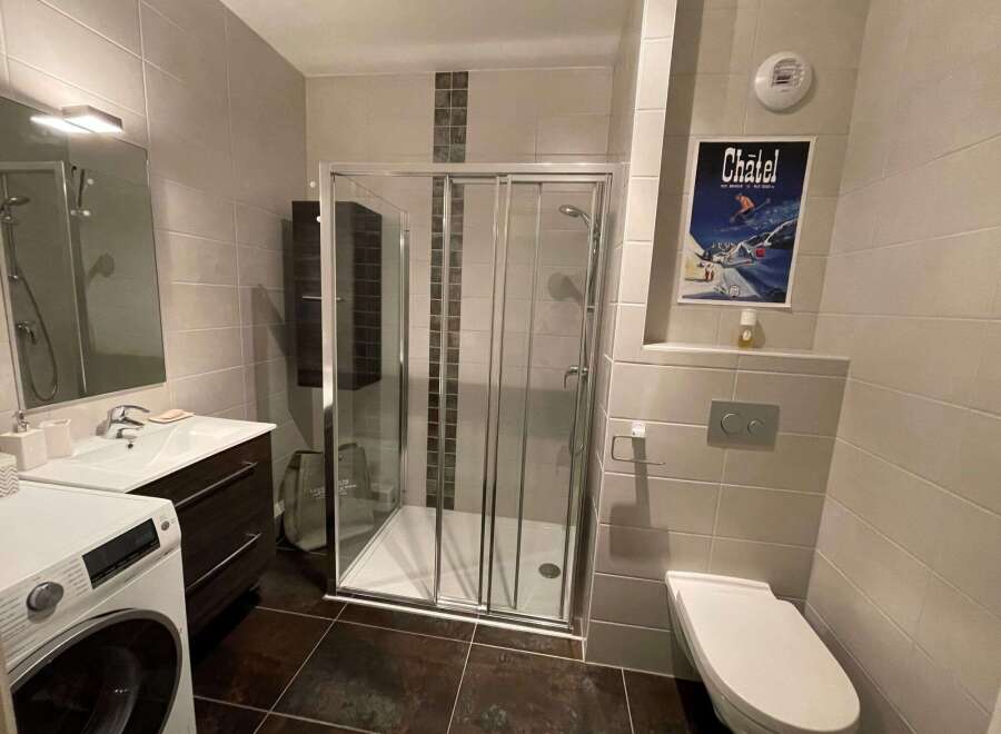 This modern bathroom features a sleek glass shower, perfect for a refreshing start to your day.