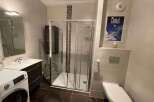 This modern bathroom features a sleek glass shower, perfect for a refreshing start to your day.