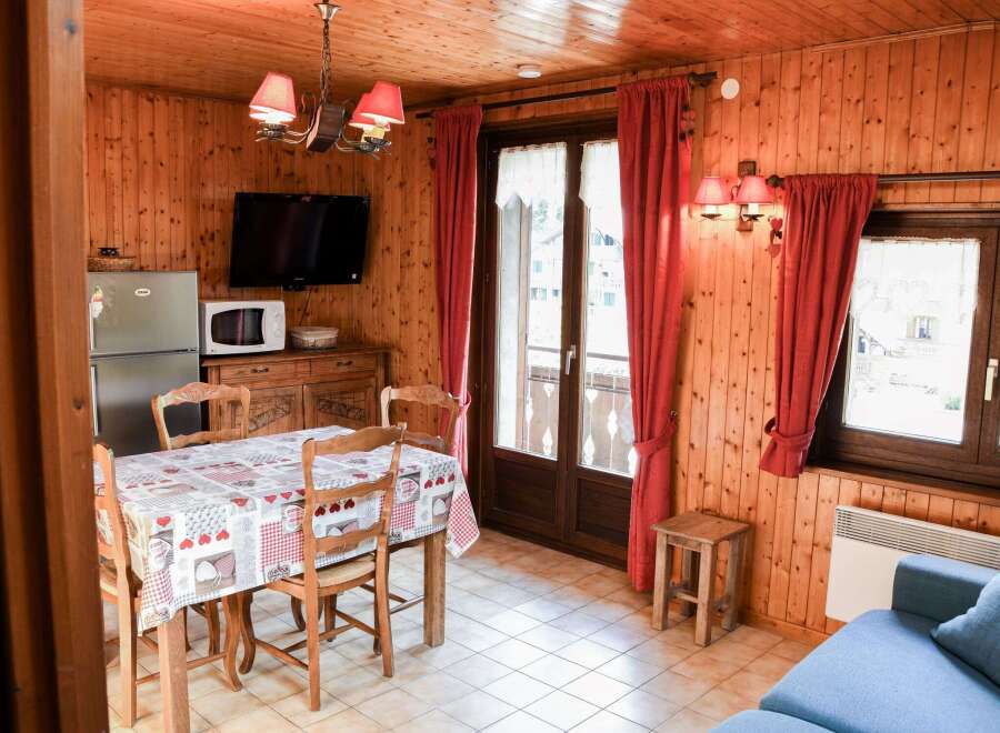 Cozy cabin interior featuring warm wood paneling and a charming dining area.