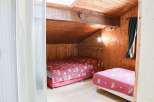Cozy bedroom with wooden walls and ceiling, creating a warm and inviting atmosphere.