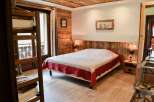 Cozy bedroom with wooden walls and ceiling, creating a warm and inviting atmosphere.