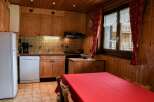 Cozy kitchen with wooden cabinets and a charming red tablecloth.