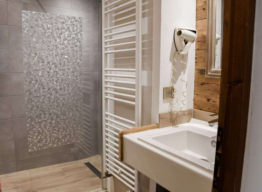 This bathroom features a modern design with a sleek white sink and a stylish shower area.