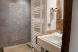 This bathroom features a modern design with a sleek white sink and a stylish shower area.