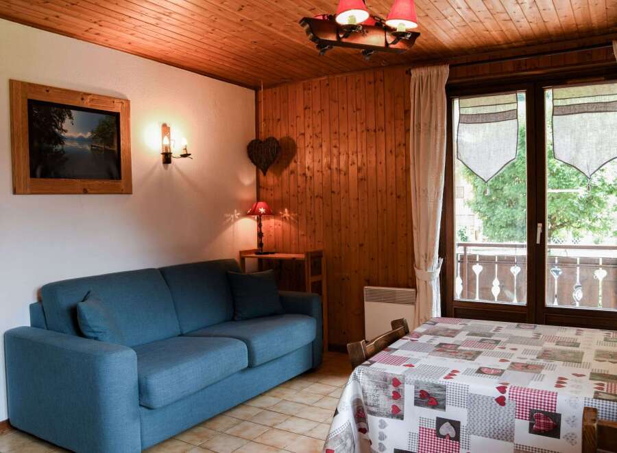 Cozy up in this charming apartment featuring a comfortable blue sofa and a rustic wooden interior.