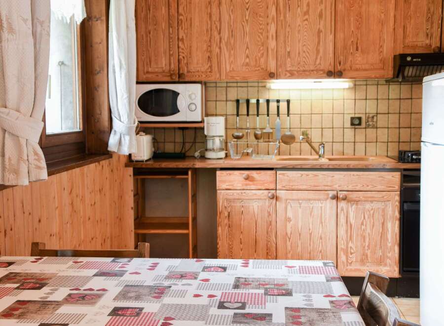This charming kitchen features warm wooden cabinetry and a cozy dining area.