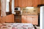This charming kitchen features warm wooden cabinetry and a cozy dining area.